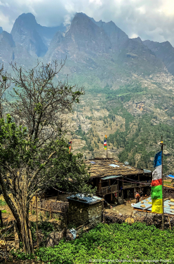 A row of typical houses, built as a single room (cooking, eating, sleeping) with a barn underneath. There is no running water in the homes, or electricity. Wires that are the start of the necessary infrastructure can be seen, but construction was halted after the 2015 Nepal earthquakes, the first and largest of which was centered to the immediate south, in Gorkha, and devastated much of the valley.